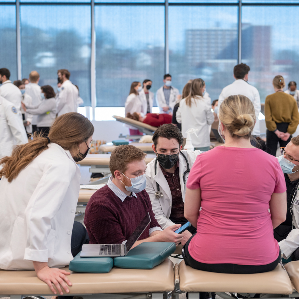 OMM lab classroom with faculty , students, and patients