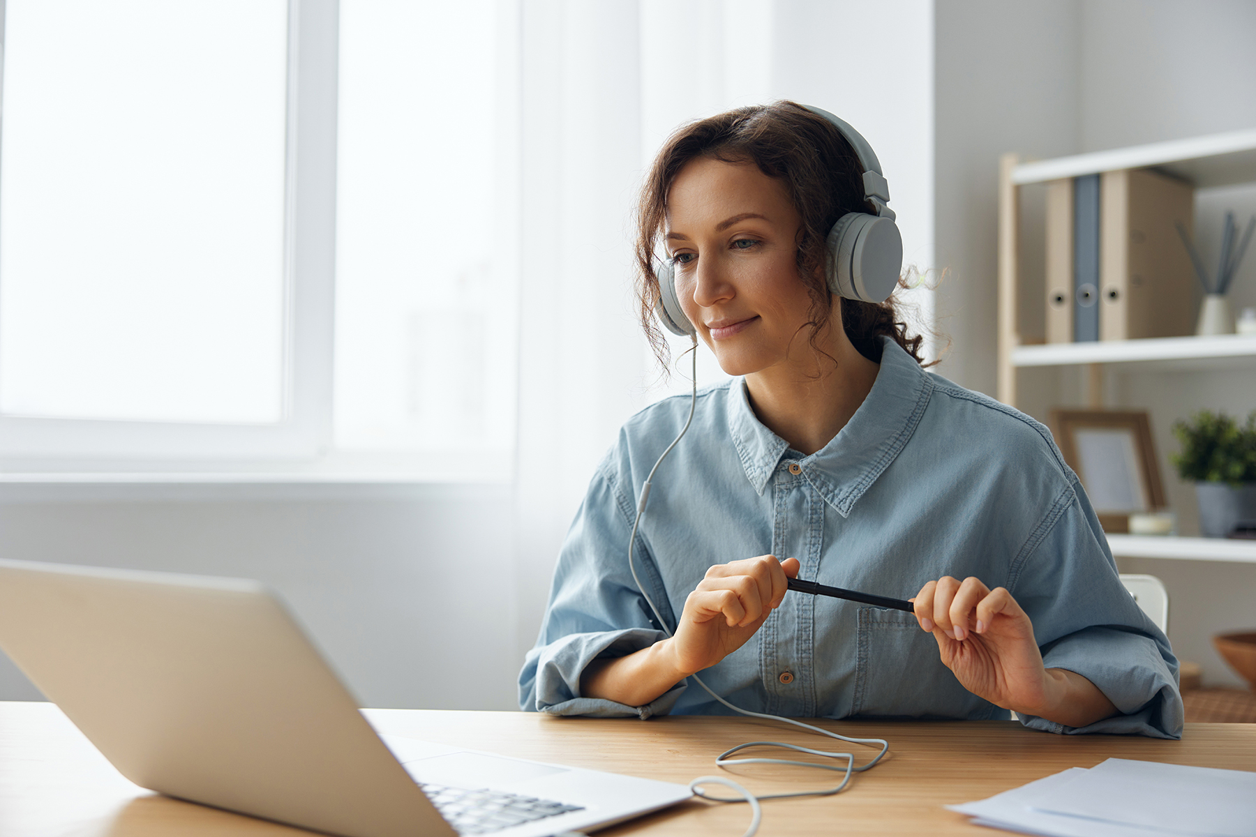 woman sitting at laptop with headphones on