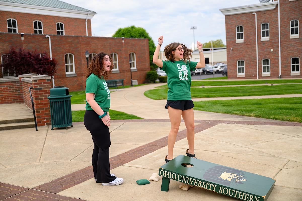 two students playing corn hole