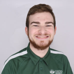 Logan in a dark green Bobcat Student Orientation shirt, smiling at the camera.