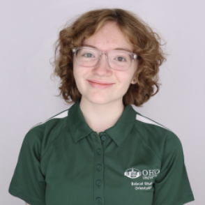 Kathleen in a dark green Bobcat Student Orientation shirt, smiling at the camera.