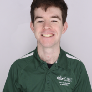 Eric in a dark green Bobcat Student Orientation shirt, smiling at the camera.
