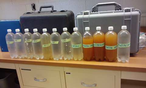 Water collected from the headwaters above the doser (far right). The orange water is from the sacrifice zone, followed by clear water 11 to 12 miles downstream.