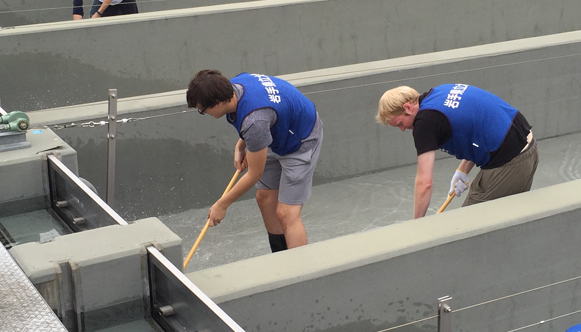 From left, in the foreground inside fish chute: OHIO Sophomore Nick Farris and Senior Ben Piper help to scrub clean the concrete fish-egg chutes at a local fish hatchery used to dispense fertilized salmon roe into a nearby river as part of the OHIO-IPU Ts