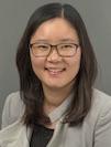 Headshot of a smiling Hyeyoon (Rebecca) Choi in a tan suit.