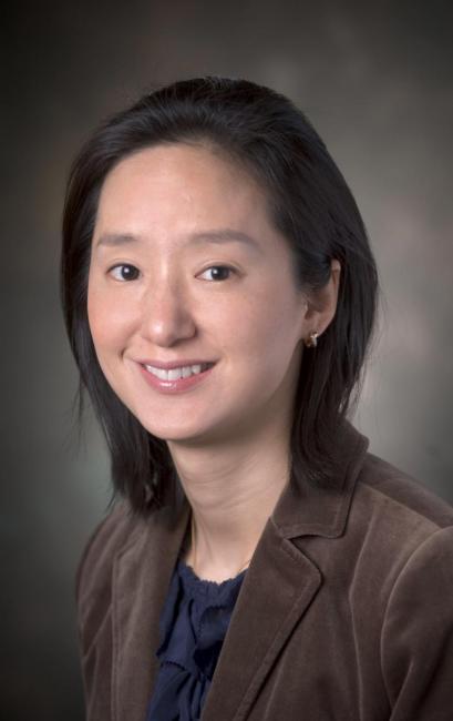 Headshot of a smiling Jeesun Jung in a dark suit