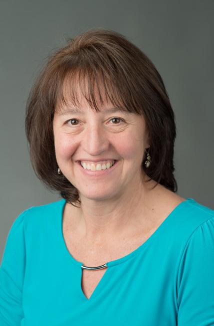 Headshot of a smiling Dianne Gut-Zippert wearing a blue blouse