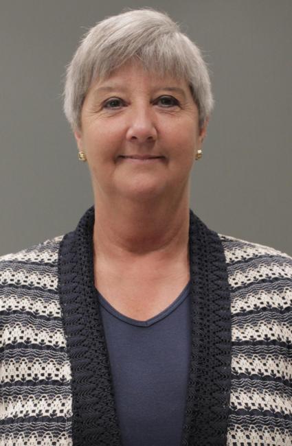 Headshot of a smiling Helen Watson wearing ablue and white striped sweater and blue top.