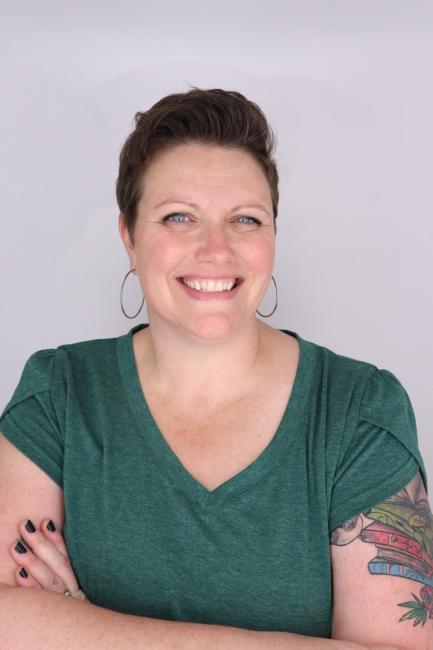 A headshot of Dawn Mooney smiling and wearing a green v neck shirt