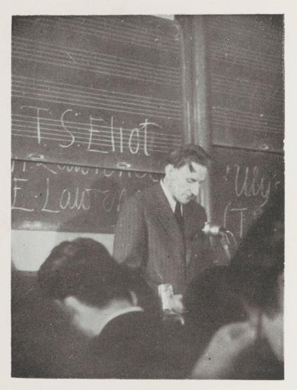 Edmund Blunden lecturing in front of a blackboard with students visible in the foreground