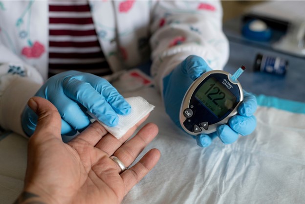  A person gets their blood glucose level checked.