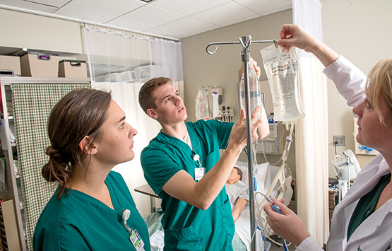 OHIO Nursing students in a real-world setting learning about IV bags.
