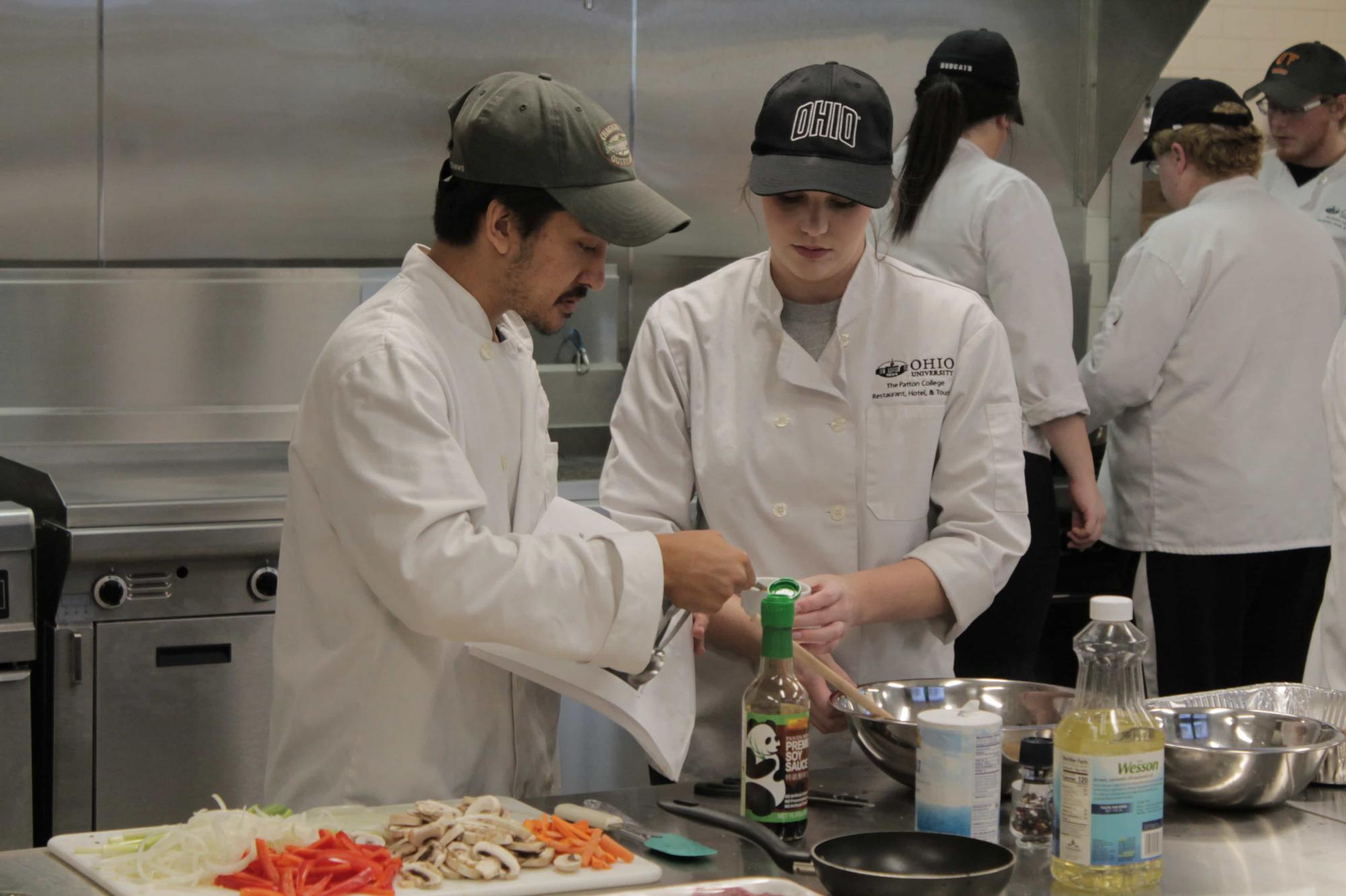Culinary students work together while cooking.