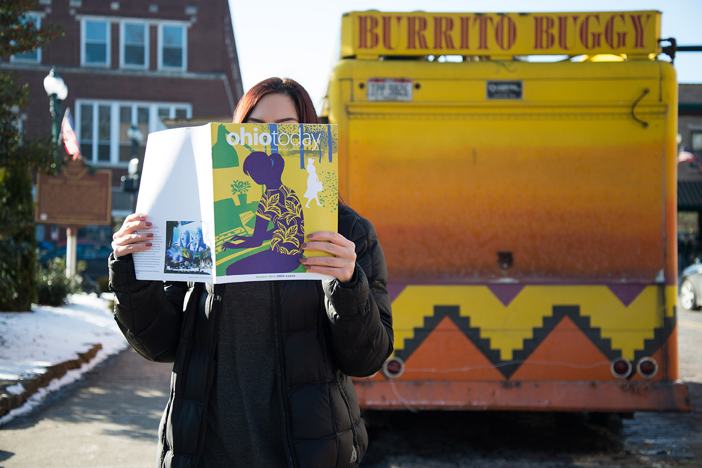 Person reading Ohio Today magazine in front of the Burrito Buggy