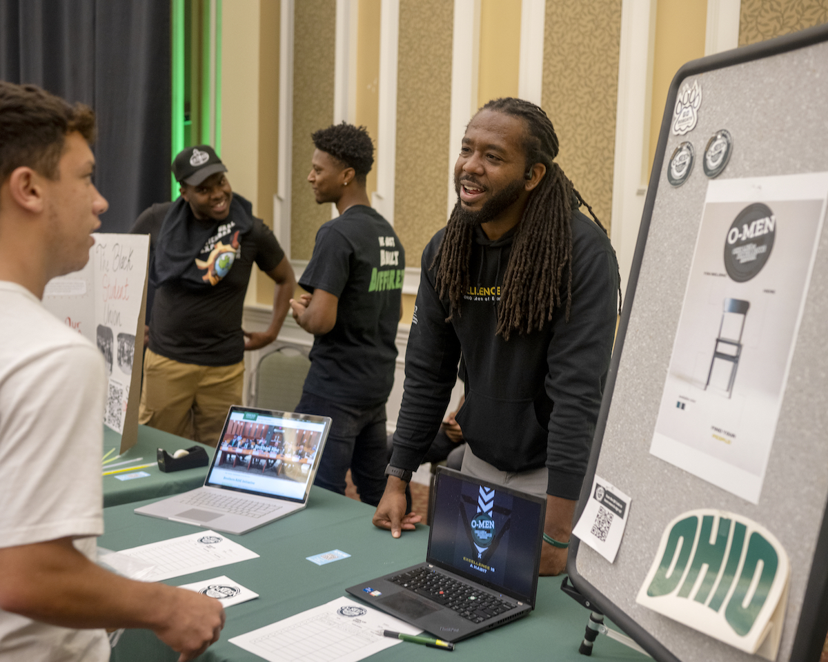 Acie Clayborne talks to a student interested in the Ohio Men of Excellence Network.