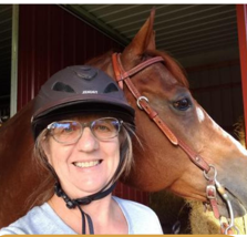 Jo Ellen Sherow, Program Manager, smiling, pictured with her horse