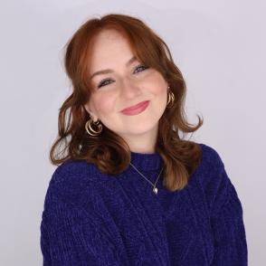 An image of Mackenzie Shuman in a dark blue sweater with a white background.