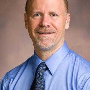 Lonnie Welch shown shoulders up wearing a blue shirt and tie