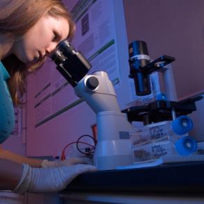 Woman looking through microscope.