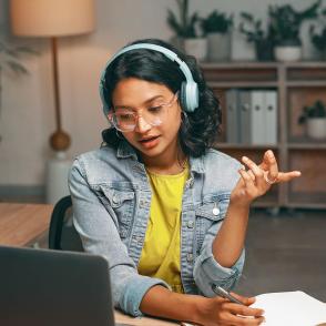 girl sitting at computer with headphones on