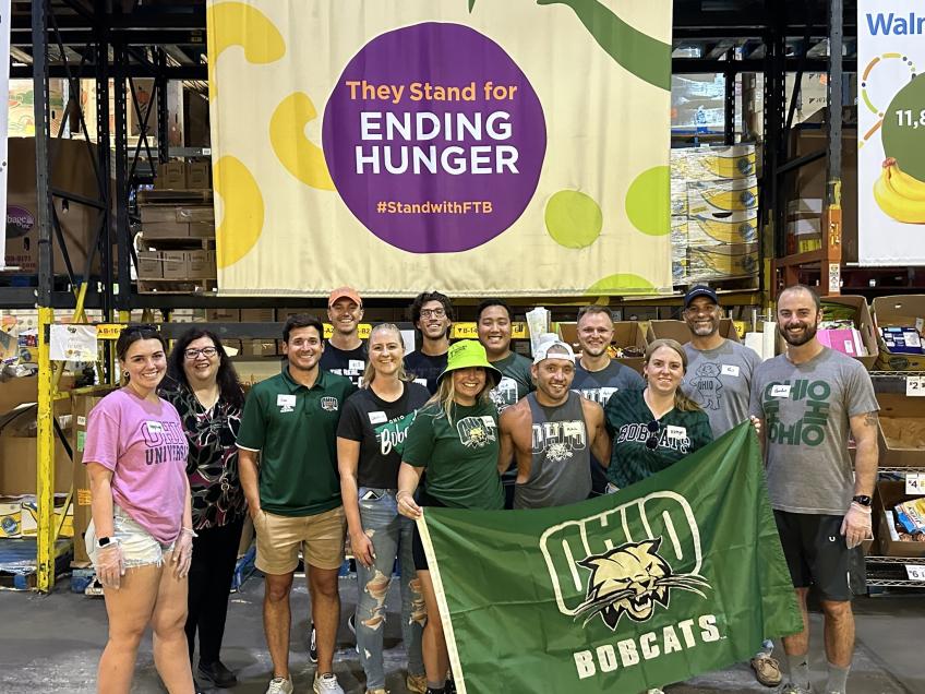 Group picture holding Ohio University Bobcats flag.