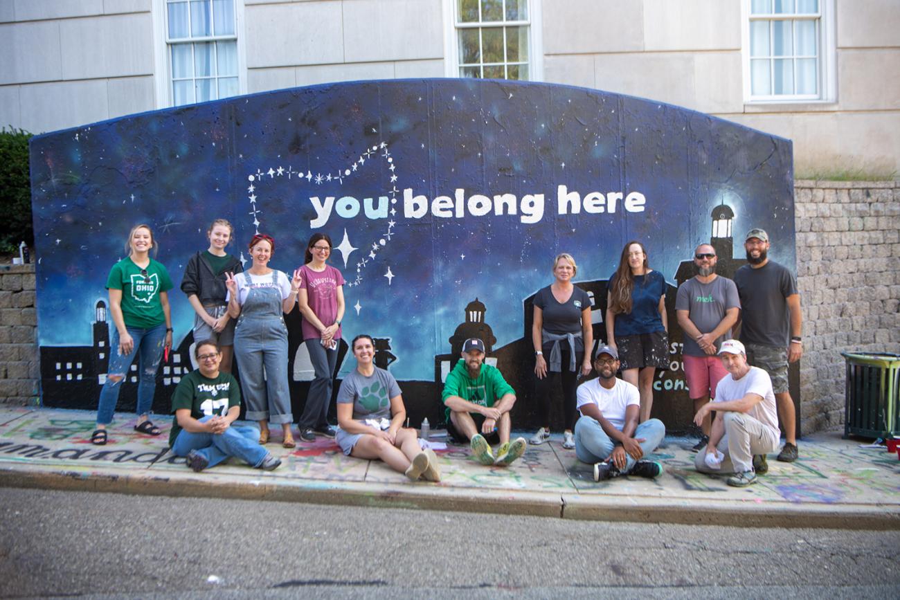 OHIO staff and students standing in front of graffiti wall
