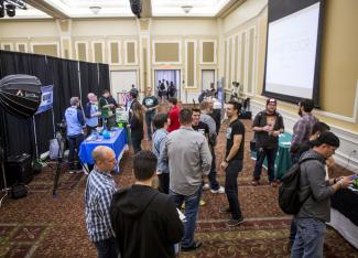 A group of people try out various video games on the BOGS exhibit floor