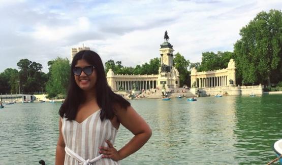 Reiya Bhat, HTC alumna, standing in front of water and monument in India