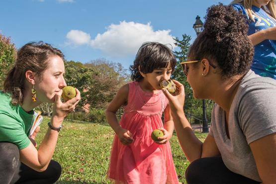 Two Ohio University students help a child during a community visit