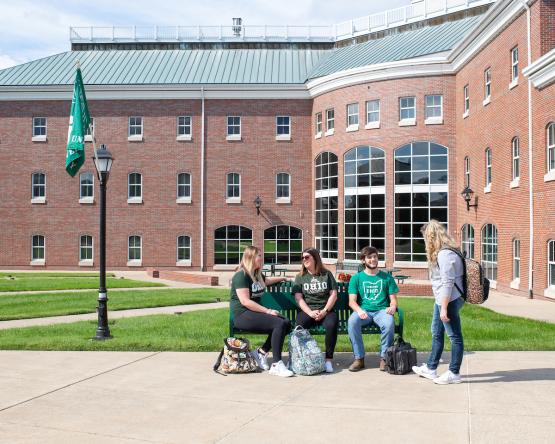 Four OHIO students talk outside on campus.