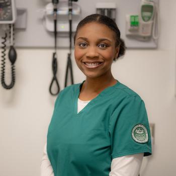 Ohio University nursing student poses while wearing scrubs with an Ohio University patch on the sleeve