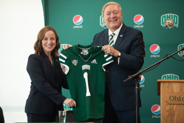 Ohio University President M. Duane Nellis gives new Athletic Director Julie Cromer a jersey at a press conference at Peden Stadium.