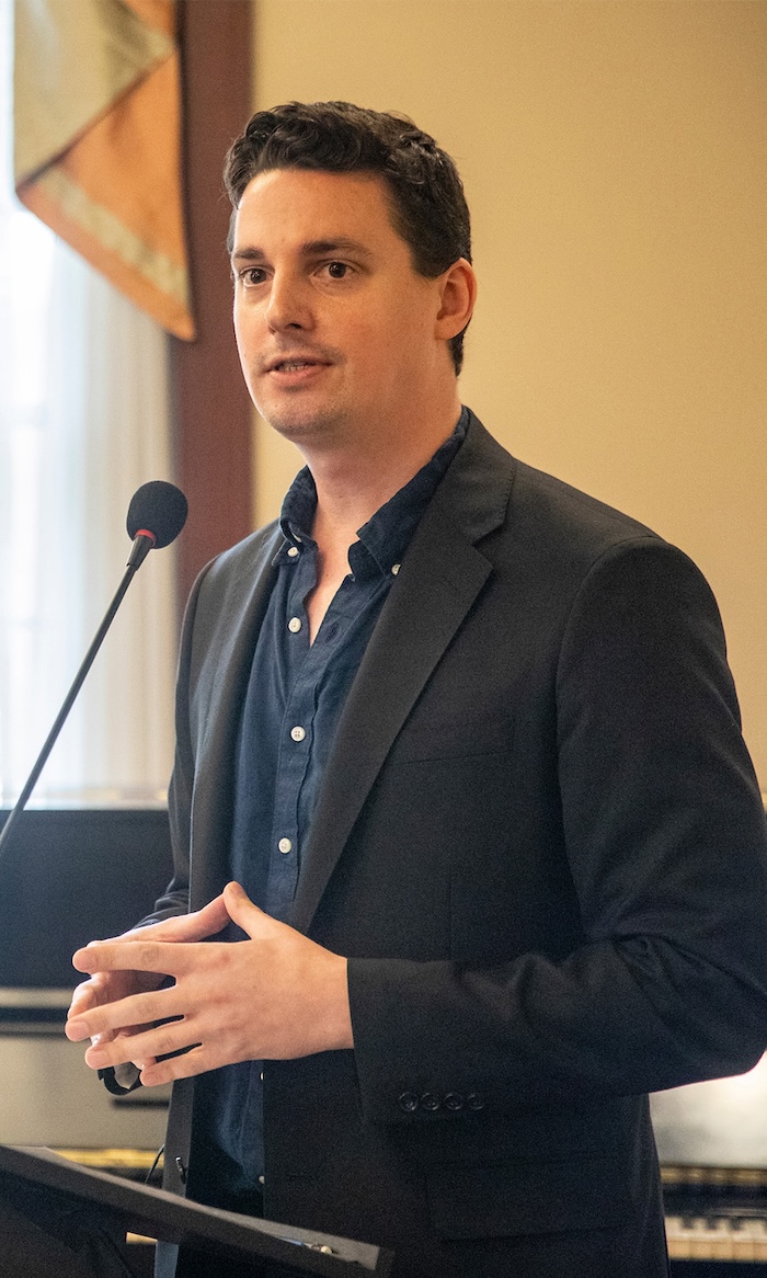  Christopher Lewis speaks at a lectern