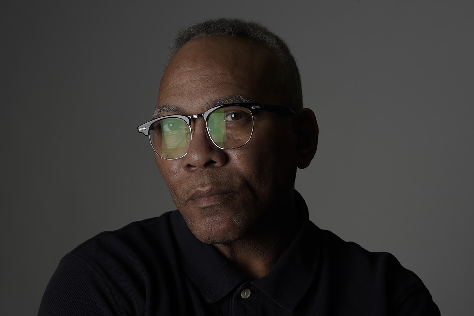 a headshot of OHIO alumnus Milt Brown, wearing a black shirt and glasses