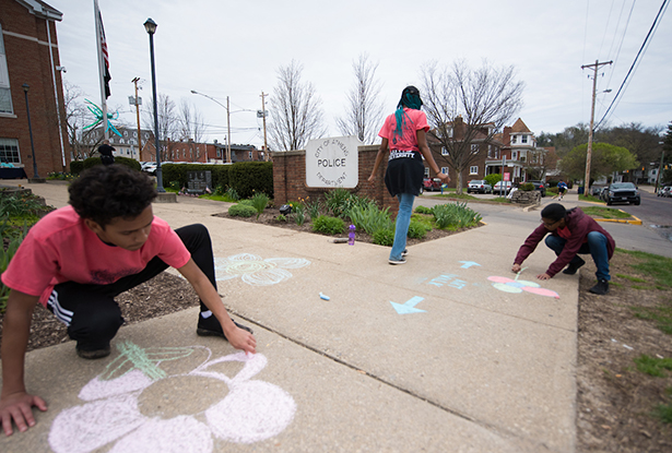 Ohio University students add some colorful artwork to the sidewalks outside of the Athens Police Department.