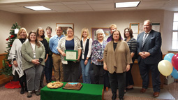Michelle Ruble (center with certificate) poses with her co-workers after receiving the November award.