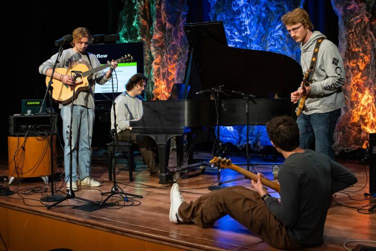 Ohio University Music Industry Summit workshop participants are shown playing musical instruments on stage