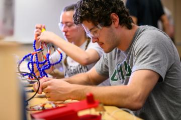 Engineering students are shown building robots in an OHIO class