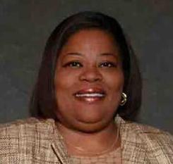 Headshot of Tara Fikes, smiling African American woman with chin length hair and tan suit.