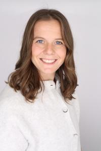 Jessica smiling at the camera in front of a white background.