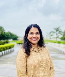 Pranauti smiling in front of a background in nature. 