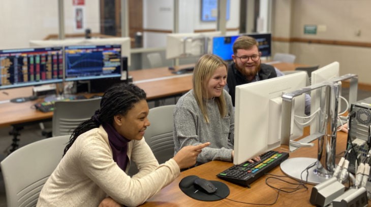 Students work together on a computer in a computer lab