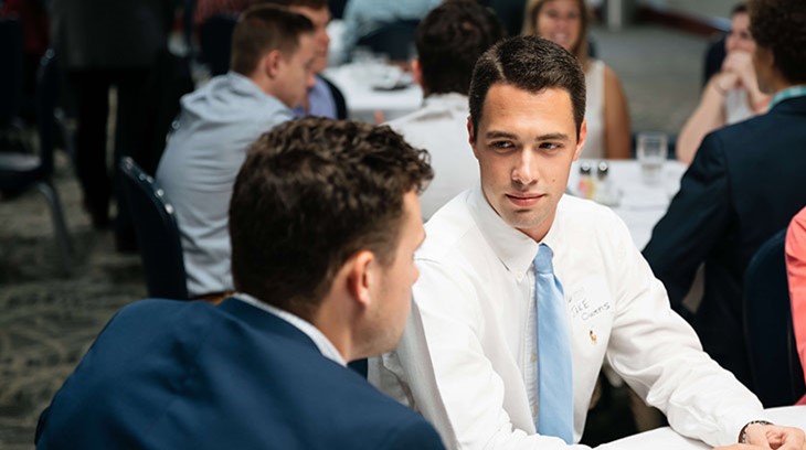 Business students talk at a table