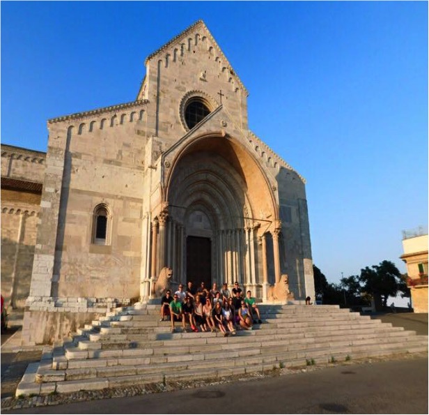 International business students pose in front of a church in Europe
