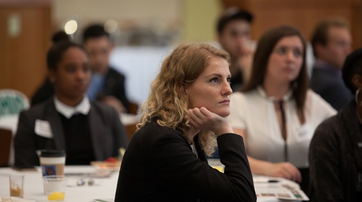 Business students listen during a presentation at a conference