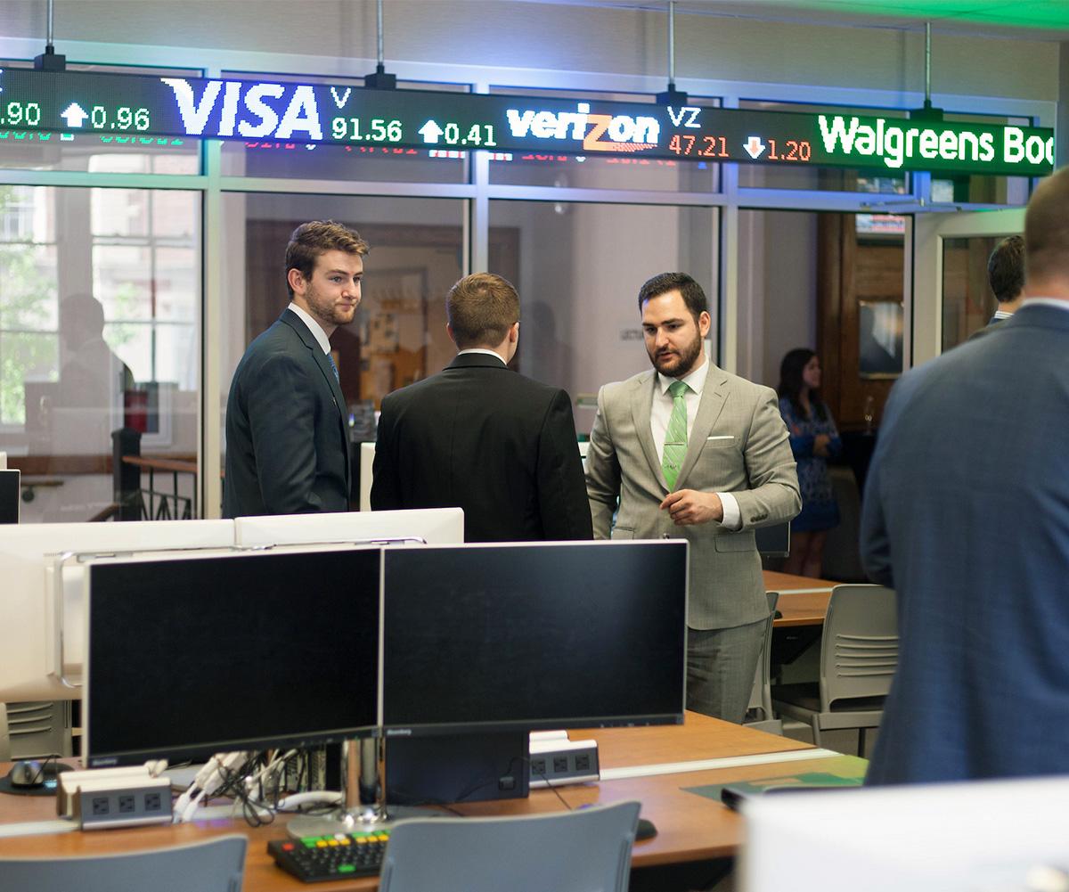 Students talk in the College of Business Trading Room.