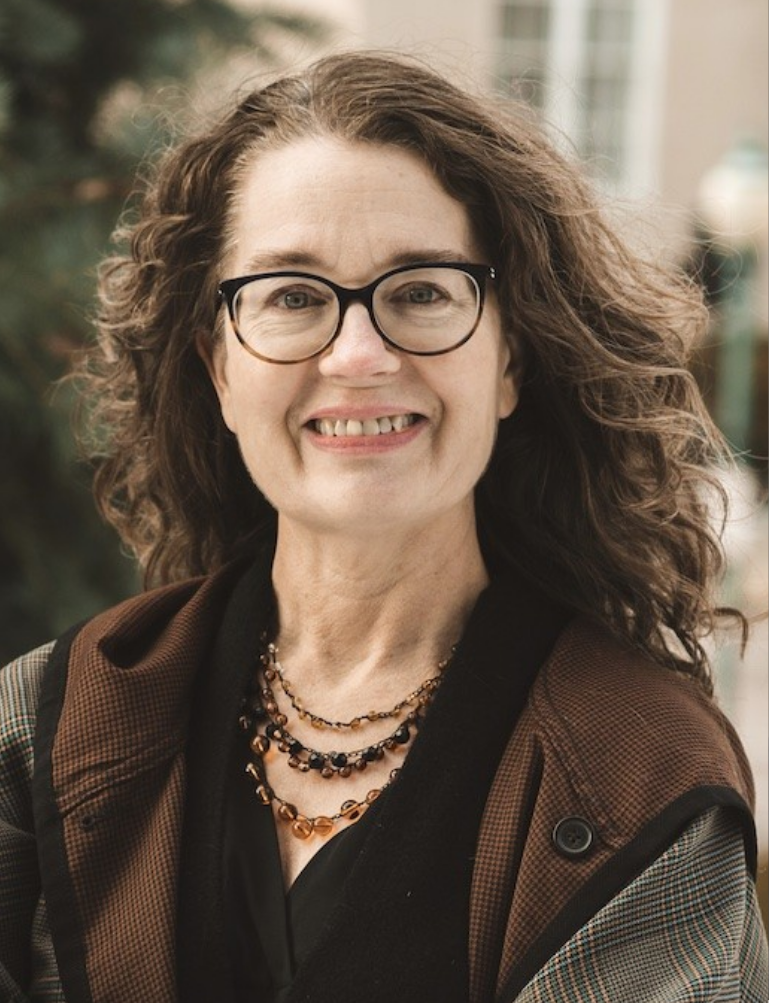 woman smiling on college green in glasses