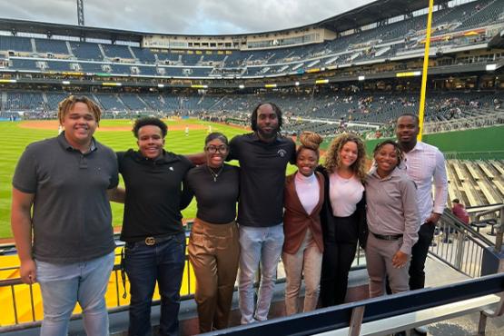 College of Business students stand in a baseball stadium together