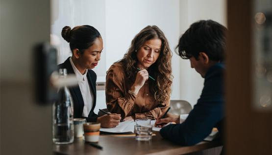 HR Director reviewing documents in a modern office setting with colleagues