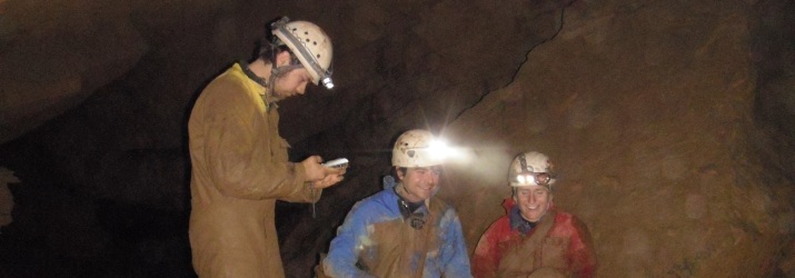 Geologists working with Dr. Greg Springer surveying a cave.